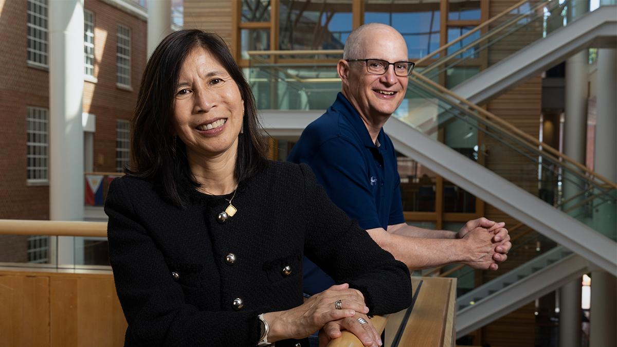 On the left, Dr. Bill Miller, and on the right, Vivian Go, both smile at the camera.